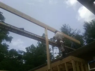 Carpenter setting a ridge beam over a new addition frame — Ice Dam Removal by Roofing Brothers in Keokuk