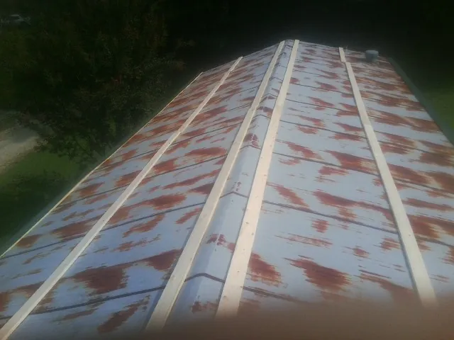 Rusted metal roof panels with new wood purlins before replacement — Storm Damage Roof Repair in Keokuk by Roofing Brothers